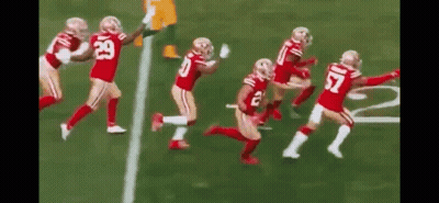Football Players Running Across Field GIF