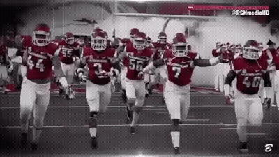 Football Players Running on Field Black and White