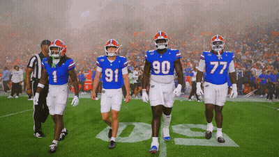 Football Players Running On Field With Flames GIF