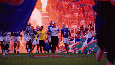 Football Players Running On Field With Flames GIF