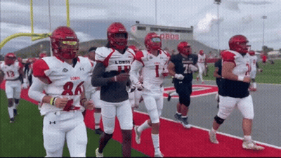 Football Players Running On Field With Lobos Stadium GIF