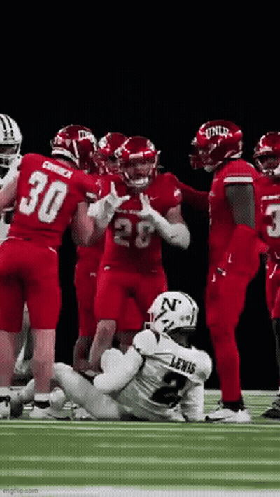 Football Players Standing Around Injured Player On Field GIF