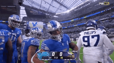 Football Players Standing On Field With Scoreboard GIF