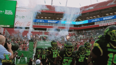 Football Players Walking Into Stadium Sponsored By Jabil And Coca-Cola GIF