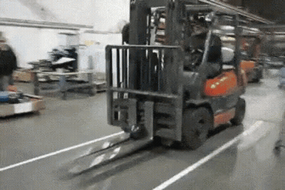Forklift Driving Down Warehouse Floor GIF