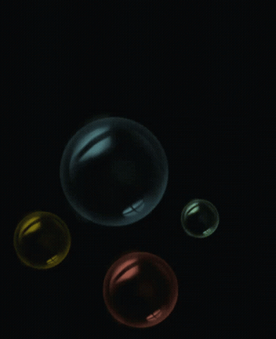 Four Colorful Bubbles Floating In Dark GIF