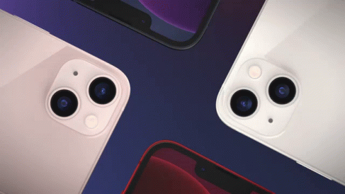 Four Different Colored Iphones Are Laying On Top Of Each Other On A Blue Surface GIF