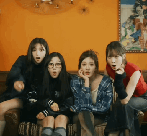 Four Girls Are Sitting On A Couch With One Wearing A Plaid Shirt With The Letter B On The Front GIF