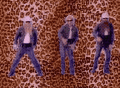 Four Men Dancing In Front Of Leopard Print Background GIF