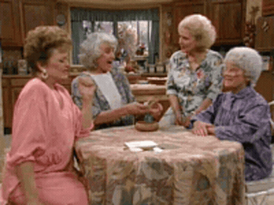 Four Older Women Are Sitting Around A Table In A Kitchen . GIF