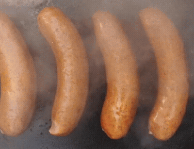 Four Sausages Are Being Cooked On A Grill And Smoke Is Coming Out Of Them GIF