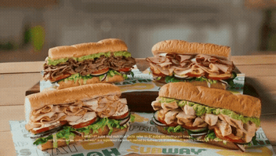 Four Subway Sandwiches Are Sitting On A Table GIF