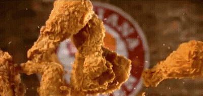 Fried Chicken Is Falling On A Plate With A Kfc Sign In The Background GIF