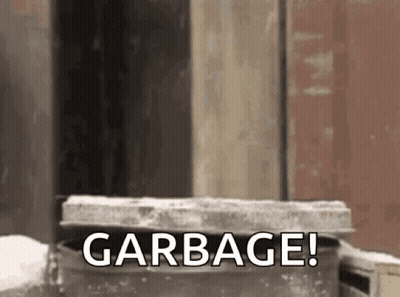 Garbage Can In Front Of Building Saying Garbage GIF