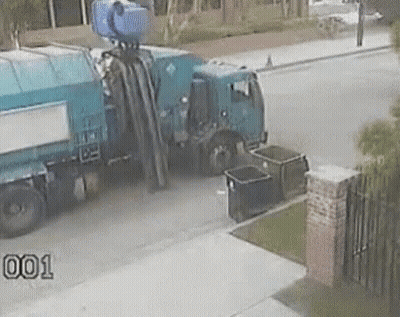 Garbage Truck Parked Next To Brick Wall GIF