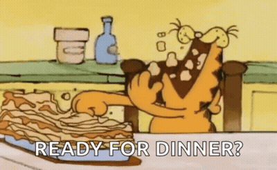 Garfield Is Sitting At A Table Eating A Lasagna . GIF