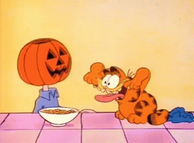 Garfield Sitting At Table With Cereal And Pumpkin Head GIF