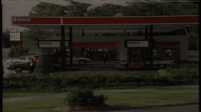Gas Station With Cars And Esso Sign GIF