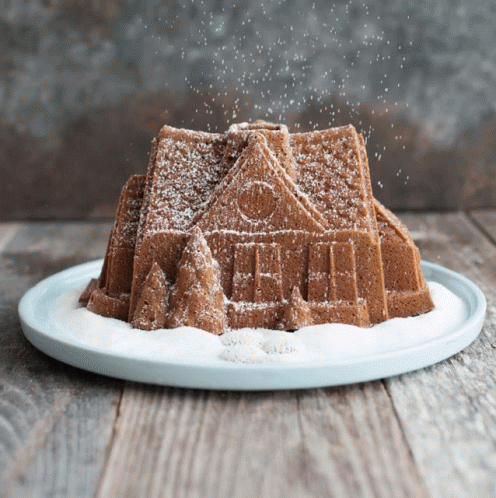Gingerbread House Cake Covered In Powdered Sugar GIF