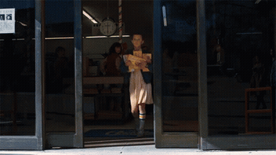 Girl Carrying Stack Of Books In Front Of Turkey Store 8 Cents GIF