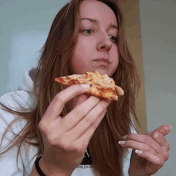 Girl Chewing Pizza With A Blank Stare GIF