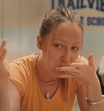 Girl Covering Mouth In Front Of Railview School Sign GIF