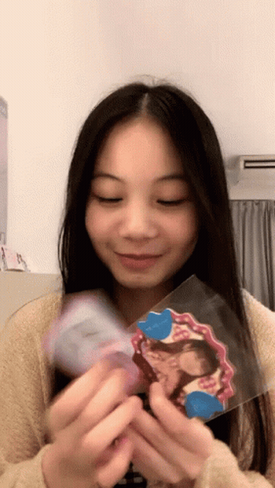 Girl Holding Picture Of Herself Smiling GIF