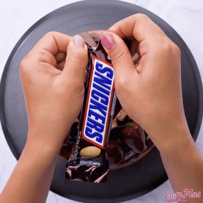 Girl Holding Snickers Bar Another Says Have A Snickers GIF