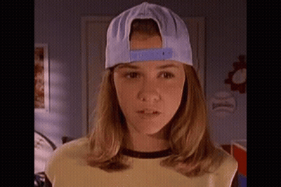 Girl In Baseball Cap And Yellow Shirt Standing In Room GIF