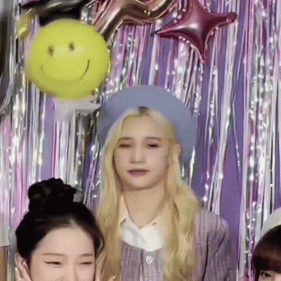 Girl In Blue Hat Standing In Front Of Balloons GIF
