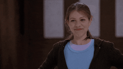 Girl In Blue Shirt And Brown Sweater Smiling GIF