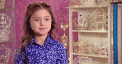 Girl In Blue Shirt In Front Of Crowns GIF