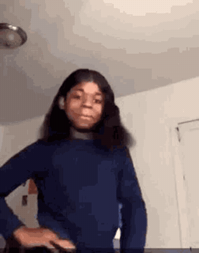 Girl In Blue Sweater Standing In Room GIF