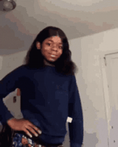Girl In Blue Sweater Standing With Hands On Hips GIF