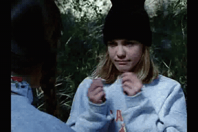 Girl In Blue Sweatshirt And Black Hat Sitting Next To Man GIF