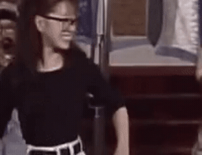 Girl In Glasses And Black Shirt At Door GIF