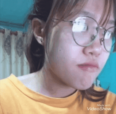 Girl In Glasses And Yellow Shirt Making A Face GIF