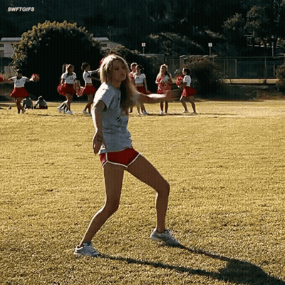 Girl In Gray Shirt And Red Shorts Dancing On Field GIF