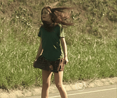 Girl In Green Shirt And Plaid Skirt Standing On Road GIF