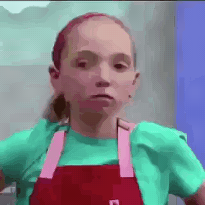 Girl In Green Shirt And Red Apron Making Funny Face GIF