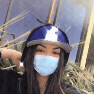 Girl In Hat And Mask Standing In Grass GIF