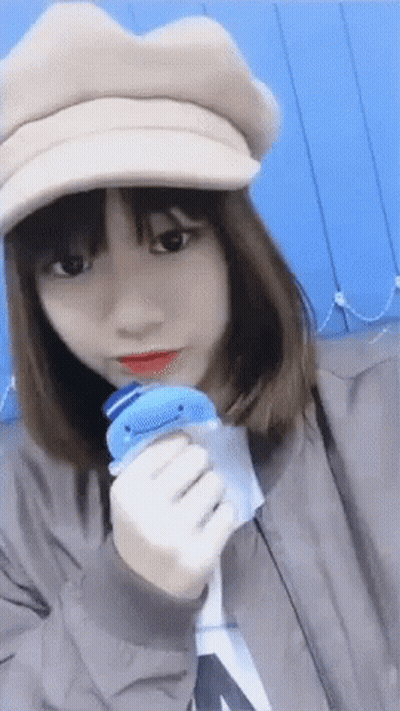 Girl In Hat Holding Blue Toy GIF