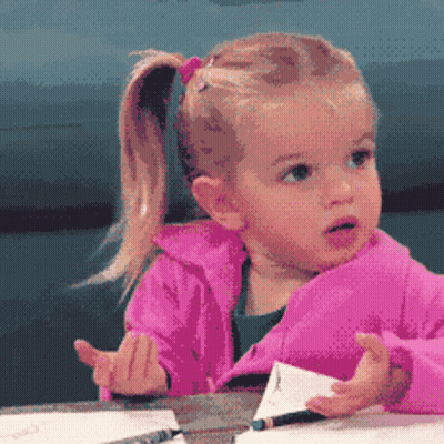 Girl In Pink Jacket Sitting At Table GIF
