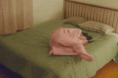 Girl In Pink Pajamas Lying On Bed GIF