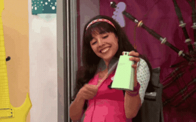 Girl In Pink Shirt Holding Green Bell GIF