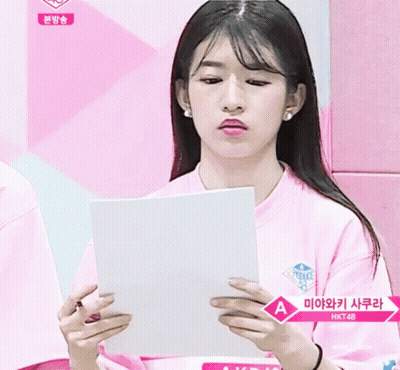 Girl In Pink Shirt Holding Paper With Letter A GIF