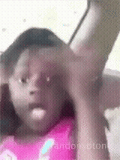 Girl In Pink Shirt Sitting In Car With Arm Outstretched GIF