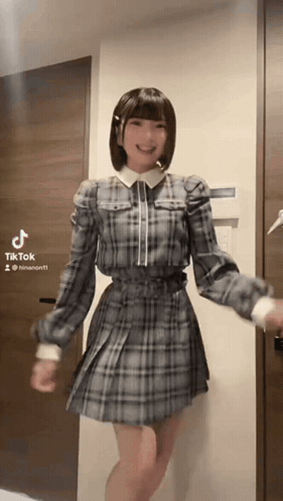 Girl In Plaid Dress Dancing By Door With TikTok GIF
