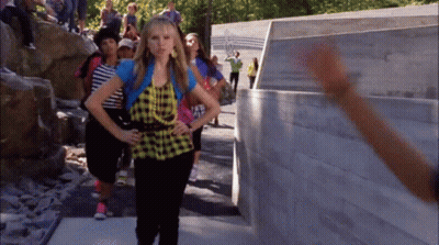 Girl In Plaid Shirt In Front Of Olympics Wall GIF
