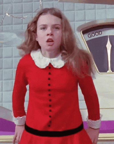 Girl In Red Dress Standing In Front Of Scale GIF
